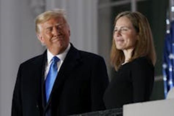 A tanned man grins at a woman with light brown hair.