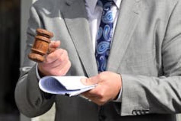 A gavel is held by an auctioneer